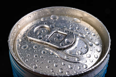 Wet pin on the can. A refreshing drink closed in a metal container. Black background.