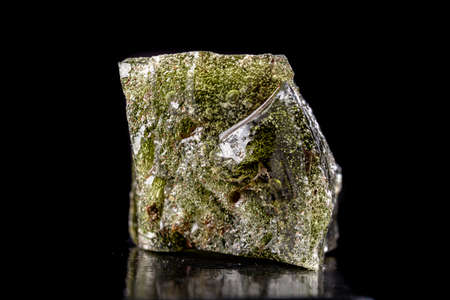 A piece of dark molten quartz with air bubbles. Melted sand in a glass factory. Dark background.