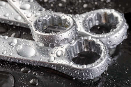 Ring spanner for loosening screws. Wet tools in the workshop. Dark background.の写真素材