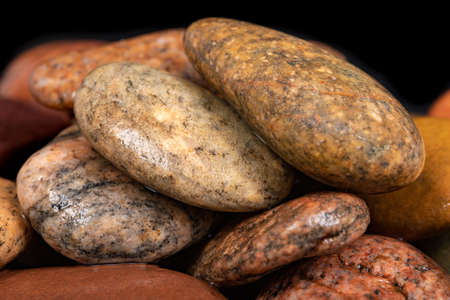 Wet oval stones found on the seashore. Stones carved by sea water. Dark background.の写真素材