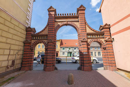 Sianow, pomorskie / Poland - August, 14, 2020: Brick gate built between tenement houses. . Summer season.のeditorial素材