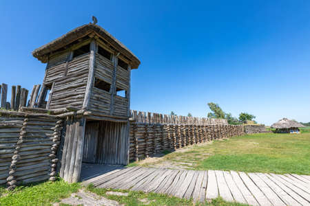 Biskupin, Kujawsko-pomorskie / Poland - August, 16, 2020: An old wooden pre-Slavic settlement. Thatched wood huts. Summer season.のeditorial素材