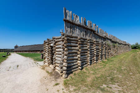 Biskupin, Kujawsko-pomorskie / Poland - August, 16, 2020: An old wooden pre-Slavic settlement. Thatched wood huts. Summer season.のeditorial素材