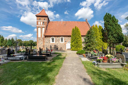 Kielbasin, Kujawsko-pomorskie / Poland - August, 18, 2020: Red brick church and cemetery in a small village. Christian temple in Central Europe. Summer season.のeditorial素材