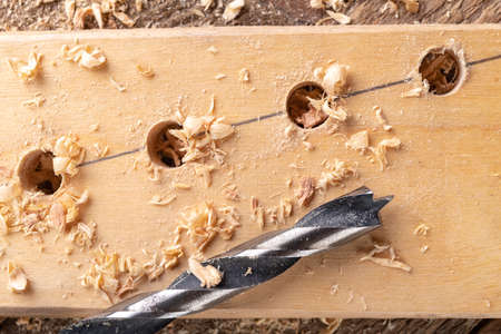 Creating holes with a metal drill in a piece of wood.の写真素材