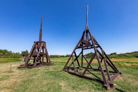 A siege machine standing on the grass in the museum. Medieval wooden machines used for the siege of castles. Summer season.のeditorial素材