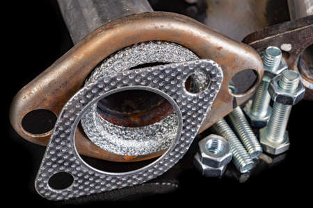 Car muffler, gaskets and bolts. Accessories and parts for car repair in the workshop. Dark background.の写真素材