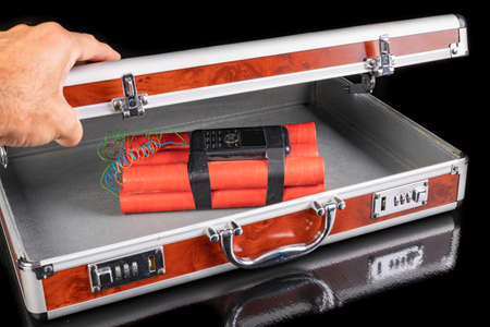 The suitcase is locked with a combination with an explosive charge. A trunk filled with explosives. Dark background.の写真素材