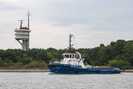 Swinoujscie, Zachodniopomorskie / Poland - August, 28, 2020: A tug in the port canal. Port in the city of Central Europe. Summer season.のeditorial素材