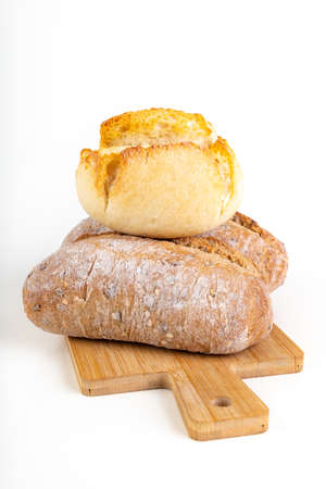 Tasty fresh bun on a wooden kitchen board. Bread prepared for eating in the household. Light background.の写真素材