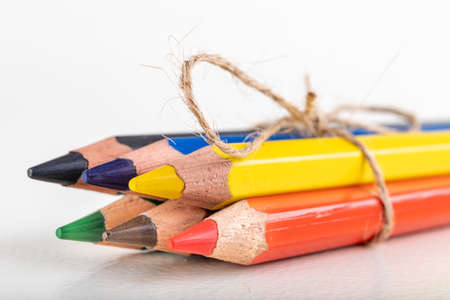 Colored wooden drawing pencils tied with string. Accessories and drawing tools for graphic designers. Light background.の写真素材