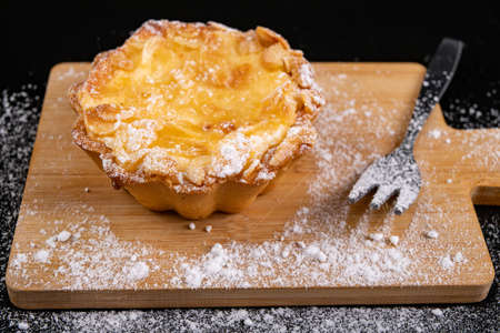 Tasty cupcake with fruit on a wooden board. Dessert prepared for serving. Dark background.