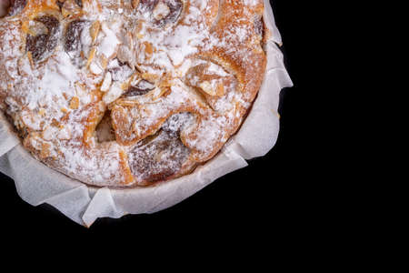 Tasty fruit cake in a paper mold. Dessert prepared for serving. Dark background.の写真素材