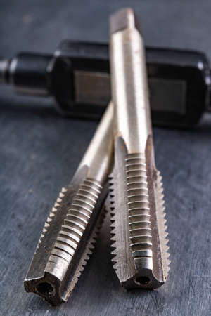 Metal thread cutting tools. Tool steel accessories for locksmiths. Light background.の写真素材
