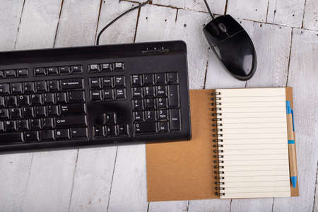 Notebook computer keyboard and mouse on a white table. Office accessories for work. Light background.の写真素材