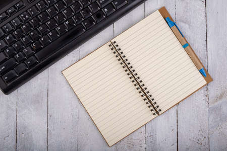 Notebook and computer keyboard on white table. Office accessories for work. Light background.の写真素材