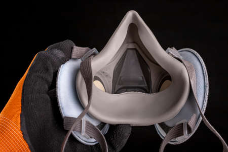 Dust mask in hand. Respiratory protection accessories. Black background.の写真素材