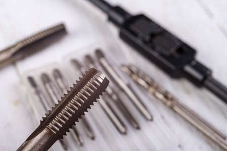 Metal taps prepared for work. Accessories in the locksmith's workshop. Light background.の写真素材