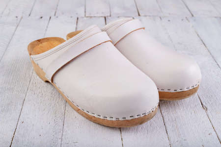 White clogs on a white table. Footwear intended for medical personnel. Light background.