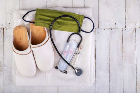 Working clothes for a medic. Medical accessories on a white table. Light background.の写真素材