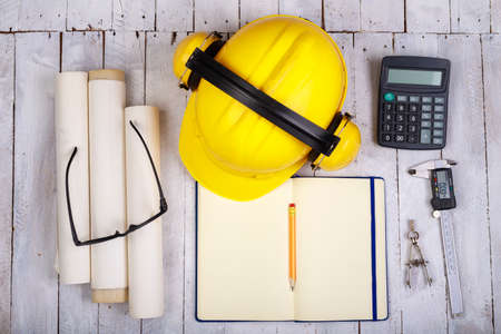View of the construction engineer desk. Notebook, caliper and other accessories on the employee's desk. Light background.の写真素材