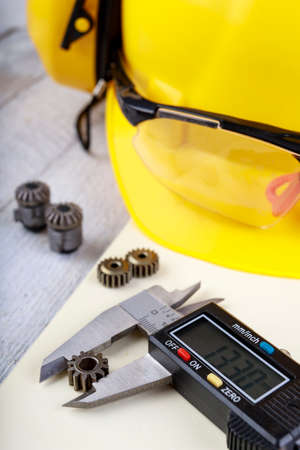Measure small metal parts with a caliper. Accessories in the engineer's office. Light background.の写真素材