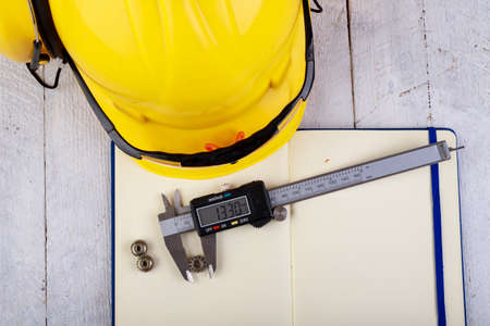 Measure small metal parts with a caliper. Accessories in the engineer's office. Light background.の写真素材