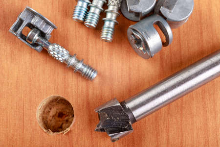 Joining chipboards with the use of specialized metal connectors. Minor carpentry work in the workshop. Light background.の写真素材