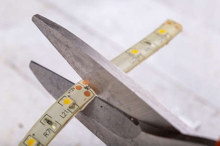 Cutting the led strip with metal scissors. Electric accessories for self-assembly at home. Light...