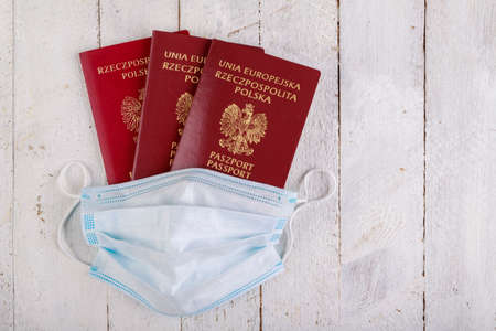 Passport and mask for health protection. International Travel Restrictions. Dark background.