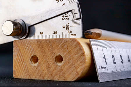 A protractor and a metal ruler to measure angles in a carpentry workshop. Accessories for measuring and drawing in a carpentry shop. Workplace - workshop.の写真素材