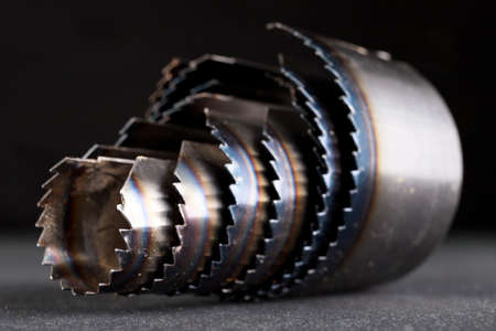 Metal holesaw blades for drilling in wood. Carpentry accessories for work in the workshop. Dark background.の写真素材