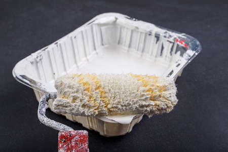 Rollers for painting with white paint. Painting accessories for home renovation. Dark background.の写真素材