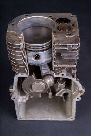 A small internal combustion engine shown in section. View of the piston and rings in the engine. Dark background.の写真素材