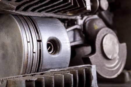 A small internal combustion engine shown in section. View of the piston and rings in the engine. Dark background.の写真素材