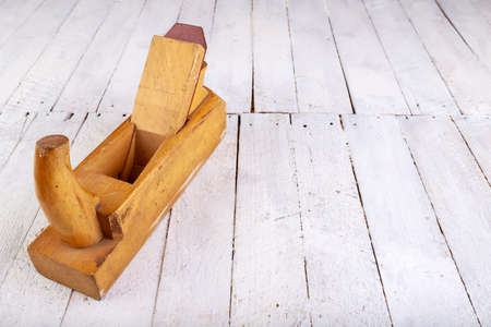 Wooden planer for wood on the table. Carpentry accessories in a home workshop. Light background.の写真素材