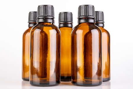 Small glass bottles for the storage of light-sensitive liquids. Containers used in pharmaceuticals. Light background.の写真素材