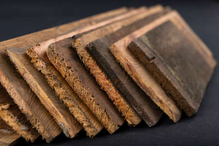 Raw boards piled up. Wood on the table in the workshop. Dark background.