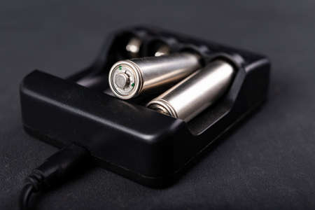 Electric battery charger on the table. Accessories for powering home appliances. Dark background.