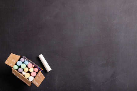 Writing and drawing chalk on a black board. Accessories for saving the lesson content at school. Dark background.の写真素材