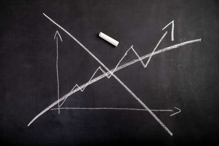 Crossed out graph of increases. Lost increases drawn on a black chalkboard. Dark background.の写真素材