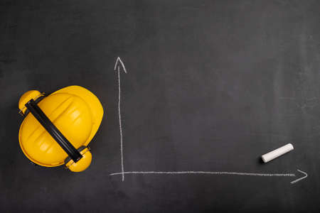 Blank chart on a black chalkboard. Helmet and construction statistics. Dark background.の写真素材