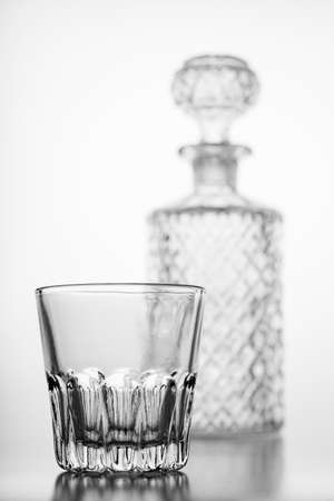 Decorated carafe and a small water glass. Decorative containers for serving water and alcohol. Light background.の写真素材