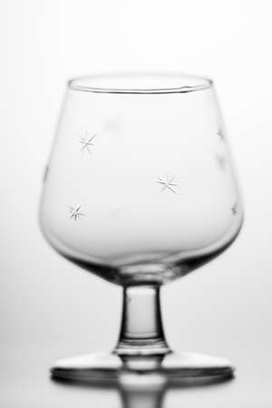 Empty cognac drinking glass. A glass container for alcohol used in the household. Light background.の写真素材