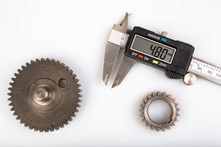 Measuring the gears with a caliper. Engineering work in the laboratory. Light background.の写真素材
