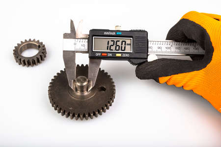 Measuring the gears with a caliper. Engineering work in the laboratory. Light background.の写真素材