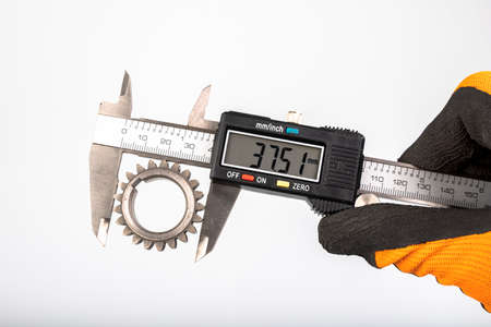 Measuring the gears with a caliper. Engineering work in the laboratory. Light background.の写真素材