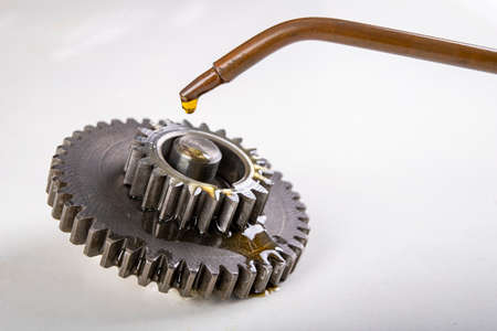 Lubricate metal gears with gear oil. Spare parts used in car workshops. Light background.の写真素材