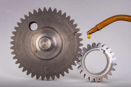 Lubricate metal gears with gear oil. Spare parts used in car workshops. Light background.の写真素材