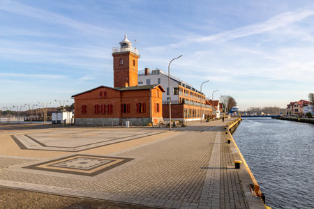 Darlowko, West Pomeranian Voivodeship Poland - December, 17, 2020: Lighthouse built in the port. Brick building as port buildings. Autumn season.のeditorial素材